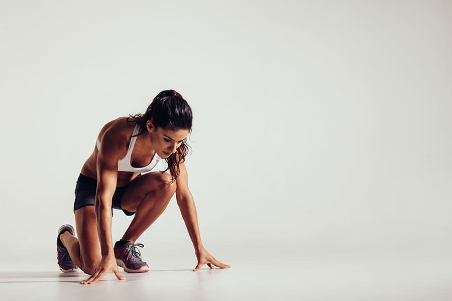 Person in kneeling position on one knee starting a yoga pose